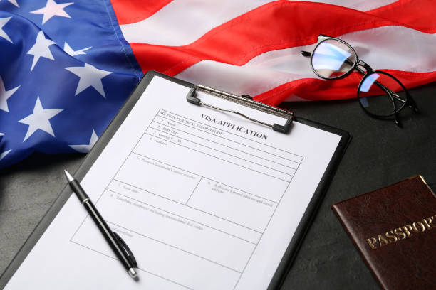 istock American flag, visa application form, passport and glasses on black table 1453972002