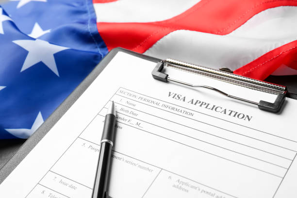 istock American flag, visa application form and pen on table, closeup 1453972198