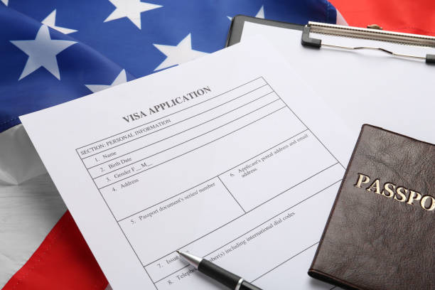 istock Visa application form, clipboard and passport on American flag, closeup 1453972228