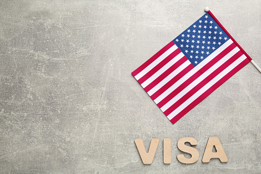 Word Visa and American flag on light grey table, flat lay. Space for text