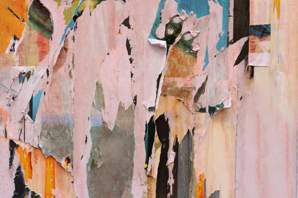 istock Pieces of torn paper peeling off wall used as billboard 1453972739