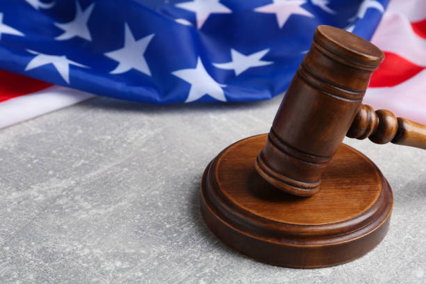 istock Judge's gavel and American flag on light grey table, closeup. Space for text 1453973971