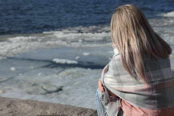 Lonely woman near river on sunny day, back view