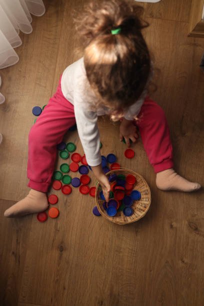 istock Little girl playing plastic bottle caps 1453974016