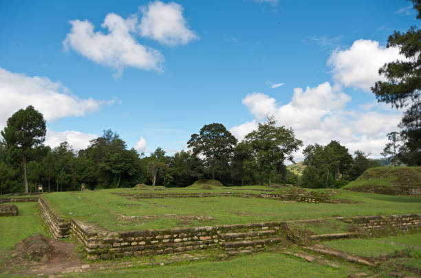 hermosa toma de paisaje del parque iximché con campos y árboles con cielo azul en guatemala - iximche fotografías e imágenes de stock