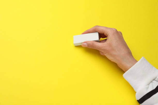 istock Woman erasing something on yellow background, closeup. Space for text 1453974177