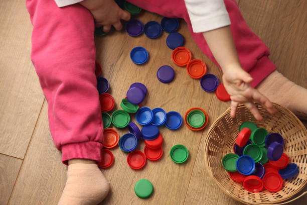 istock Little girl playing plastic bottle caps 1453974206