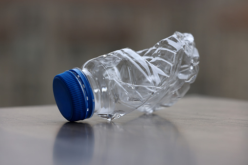 Crushed blue plastic bottle on table