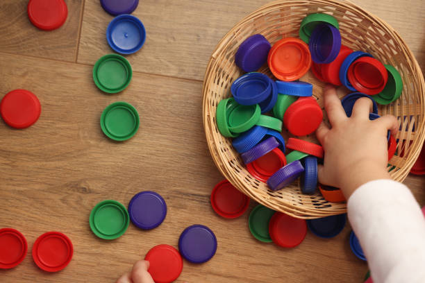 Little girl playing plastic bottle caps