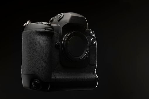 Professional digital single lens reflex camera over black background