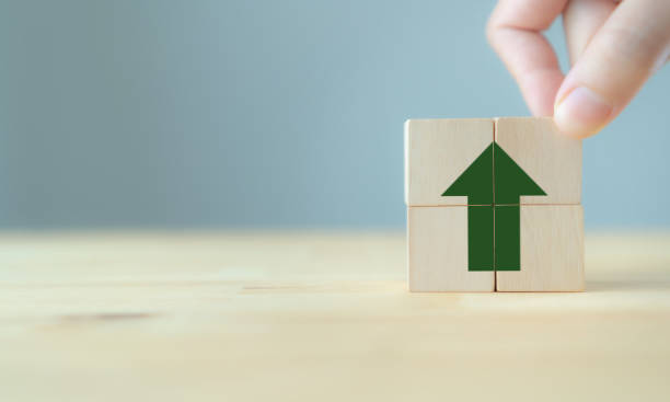 istock Green arrow points up sign on wooden cube block and copy space. 
Breakthrough and progress concept. Increasing of business performance, productivity, efficiency , investment, value added, pricing. 1453980006