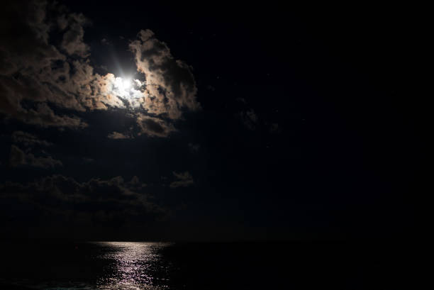 istock Night beach, sea and moonlight with clouds 1453981385