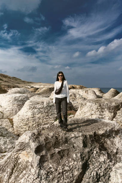 Woman standing on a cliff overlooking ocean