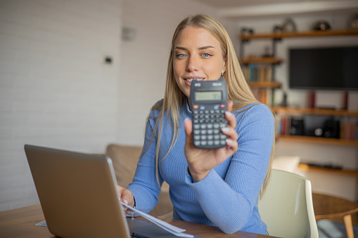 Woman planning home budget and using calculator