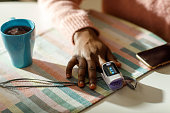 A Black Woman Measures Her Oxygen Level At Home Using A Pulse Oximeter