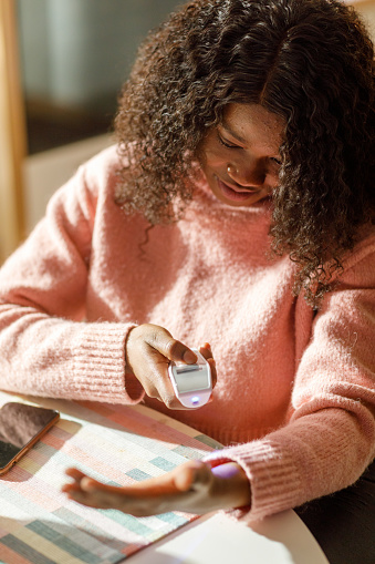 A young black woman takes her temperature