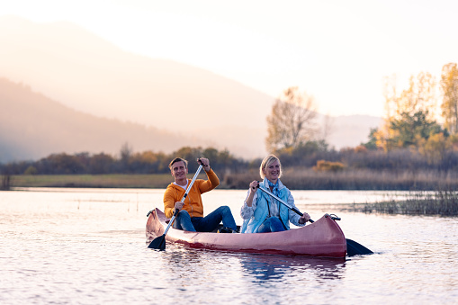 Excursionists enjoy and have fun exploring Cerkni Lake in good weather and at sunset.