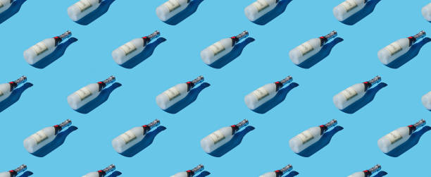 istock Pattern of champagne bottles on blue pastel background 1453987434