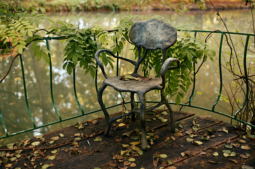 Vintage forged chair near the pond