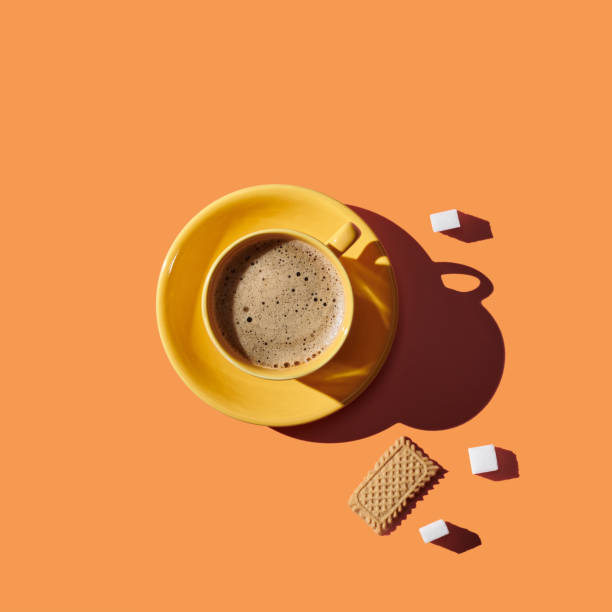 Top view of a cup of coffee on orange pastel background stock photo