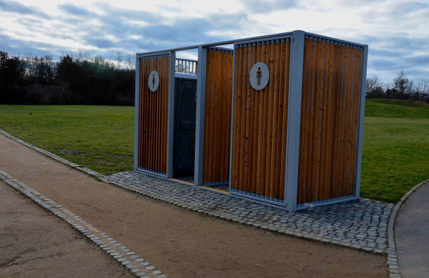 istock closing cage for placing chemical toilets. unsightly plastic boxes are inside a metal house with a flat roof and wooden slats on the walls. athletes in park or mothers with children can pee, wash hand 1453992030