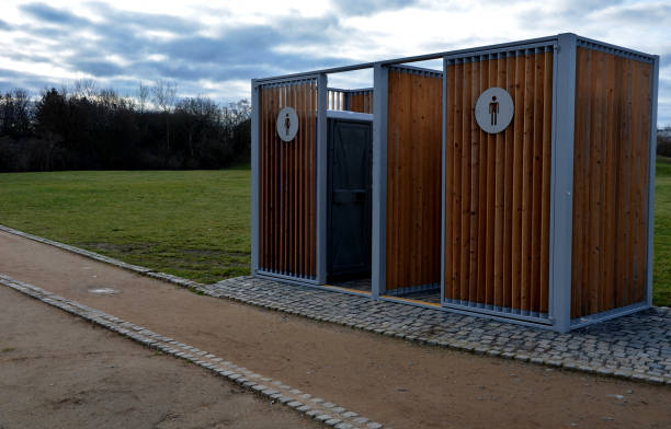 istock closing cage for placing chemical toilets. unsightly plastic boxes are inside a metal house with a flat roof and wooden slats on the walls. athletes in park or mothers with children can pee, wash hand 1453992037