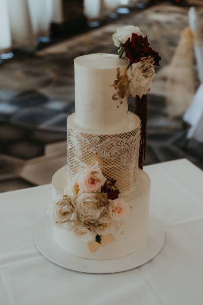 istock Three-tiered wedding cake with flowers on a table 1453993054