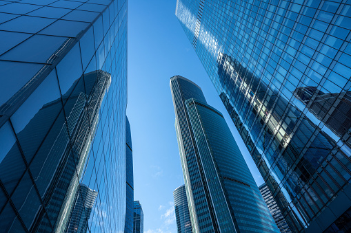 Skyscrapers, business buildings at sunny day with clear blue sky, looking up