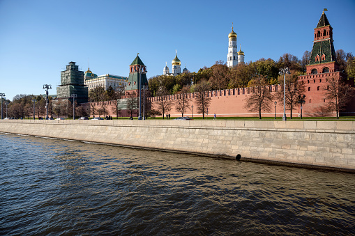 Moscow, Russia - April 29, 2019: Embankment and city traffic near Zaryadye park, Kremlin towers and St Basil Cathedral in sunny day