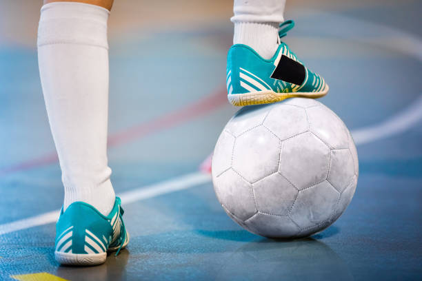 piedi del giocatore di calcio al coperto della squadra bianca calpestano il pallone da calcio per il calcio d'inizio sul campo di allenamento - soccer child indoors little boys foto e immagini stock