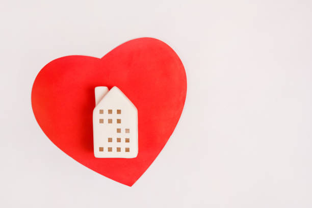 istock Toy house on the red heart on white background with copy space 1453998164