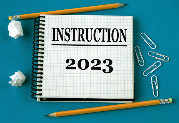 istock INSTRUCTION 2023 - word in a white notebook on a blue background with pencils, paper clips 1454002316