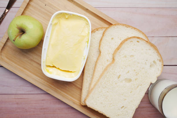 istock fresh butter in a container with bread, apple and milk on table 1454002673