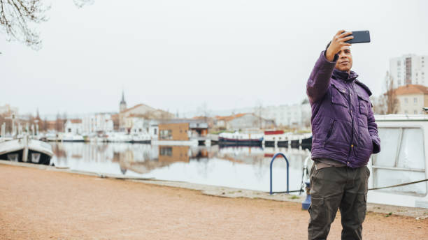 istock Hispanic man in a port taking a selfie with his smartphone 1454003972