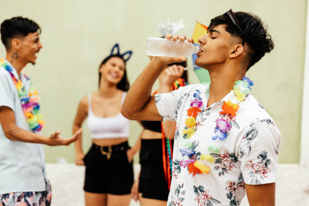 carnaval brasileño. persona bebiendo agua durante el bloque de carnaval en la calle - carnival drink people party fotografías e imágenes de stock