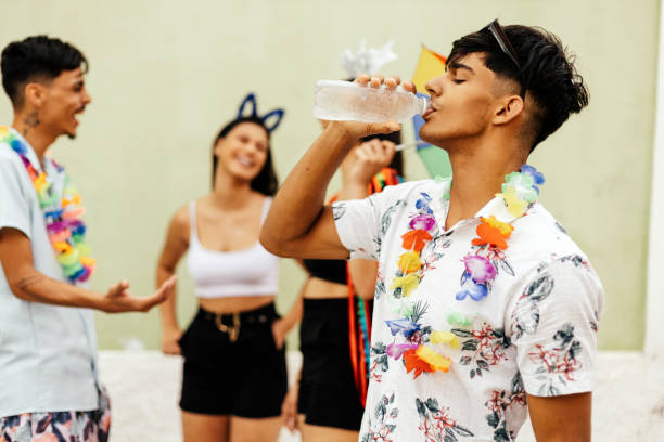 carnevale brasiliano. persona che beve acqua durante il blocco di carnevale sulla strada - drinking men water bottle foto e immagini stock