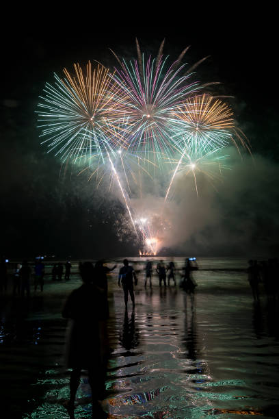 istock Fireworks on the beach. People watching watching the explosion of fireworks during the celebration of the new year. 1454007584