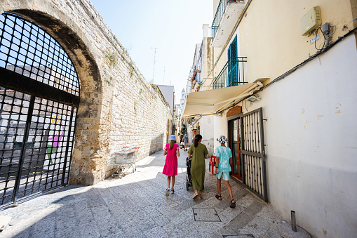 Family of tourists waking in streets Bari, Puglia, South Italy.