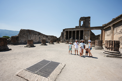 Family tourist visit Pompeii ancient city, Italy.