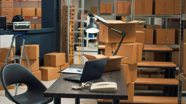 istock Empty desk room in storage warehouse area filled with carton boxes 1454008633