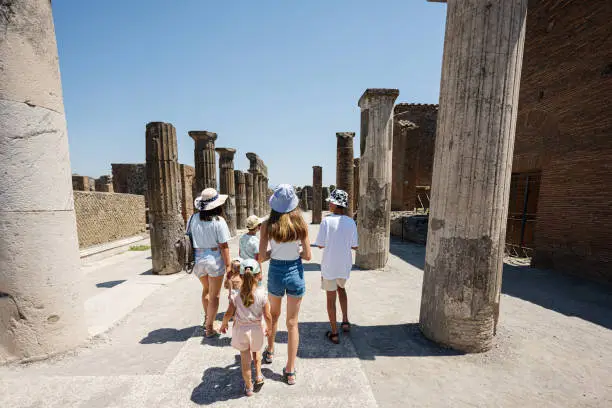 Photo of Back of family tourist walking at Pompeii ancient city, Italy.