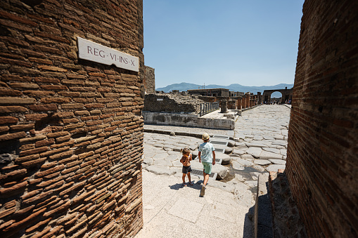 Kids tourist walking at Pompeii ancient city, Italy.