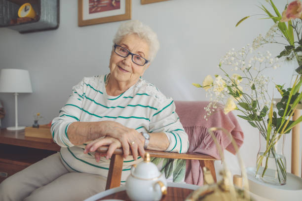 mujer senior en casa - mujeres mayores fotografías e imágenes de stock