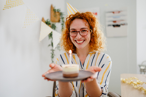 Beautiful young woman celebrating birthday in her office