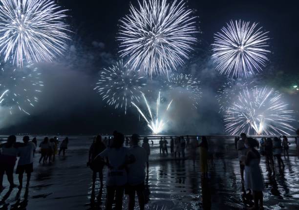 istock Fireworks on the beach. People watching watching the explosion of fireworks during the celebration of the new year. 1454011167