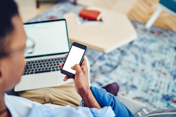 istock Crop black freelancer with laptop using smartphone 1454012559
