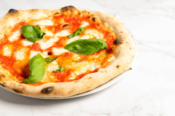 istock Close up of pizza with tomatoes, cheese and basil leaves 1454013365