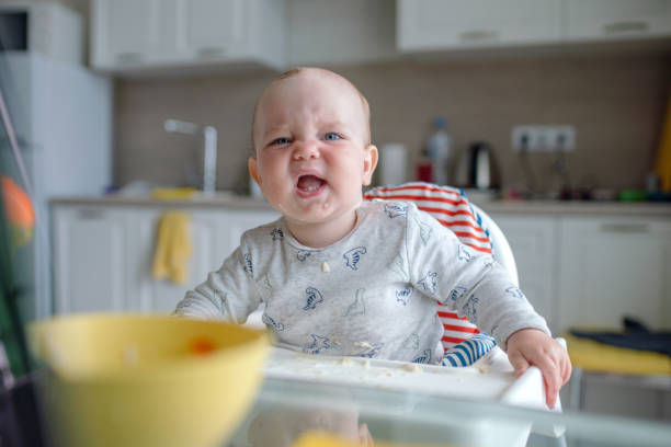 istock Sulking baby boy at the dinner table 1454015017