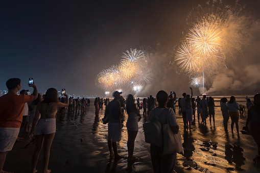 Santos city, Brazil. 01 de janeiro de 2023. Fireworks on the beach. People taking pictures with cell phones and watching fireworks during the New Year celebration.