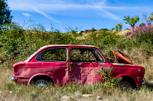 Un coche antiguo y abondonado en el campo